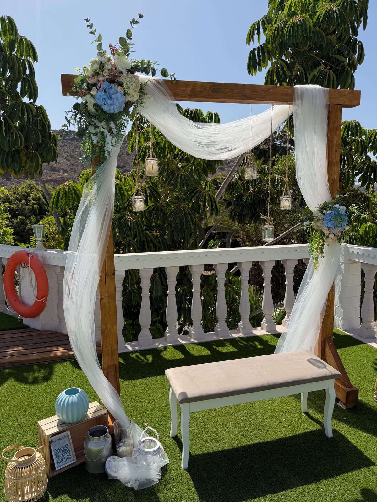 Fotocall de boda con arco de madera, tela blanca y flores en Gran Canaria