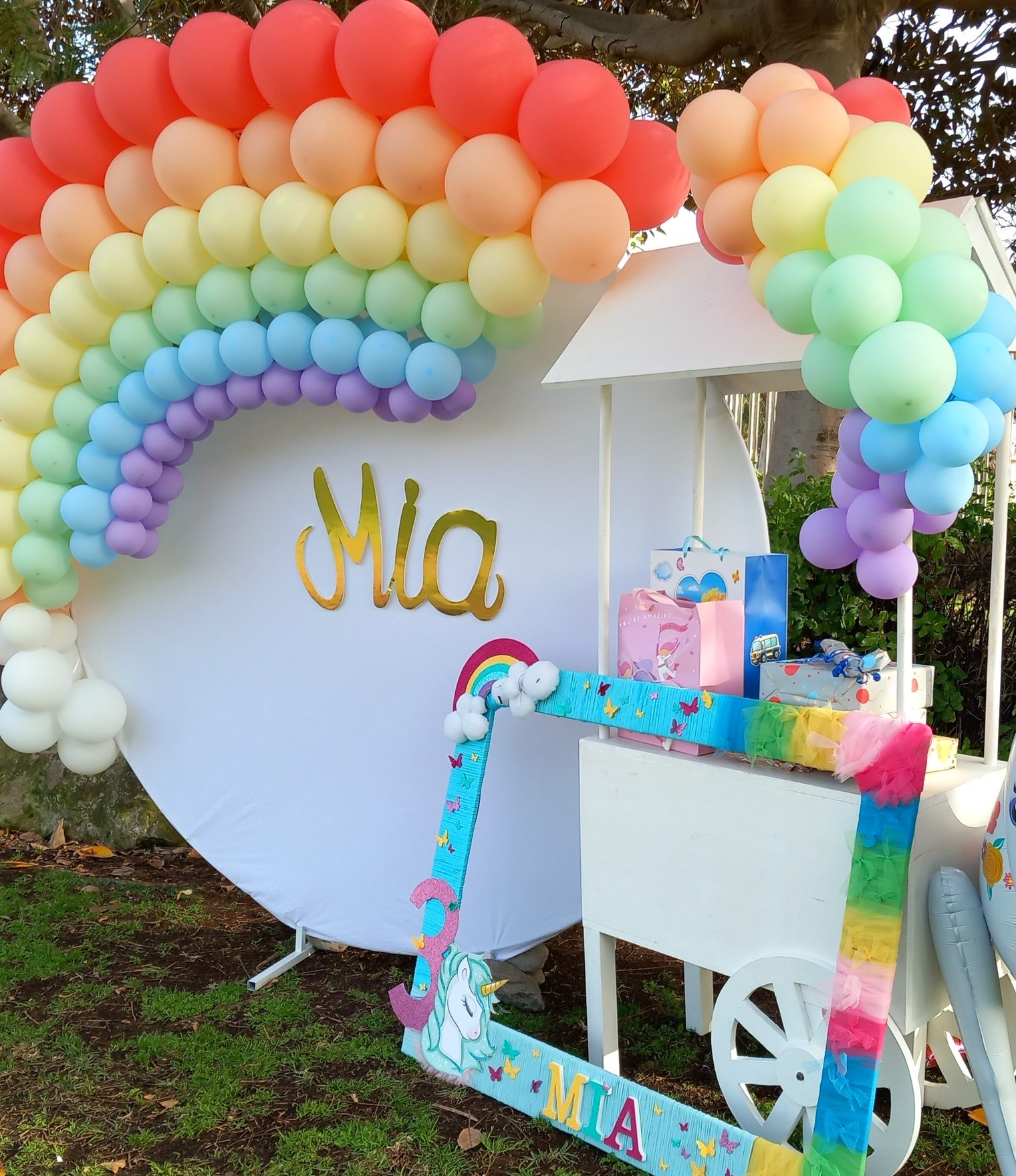 Decoración de cumpleaños con arco de globos arcoíris y fotocall personalizado en Gran Canaria